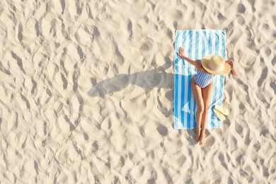 Image of Woman sunbathing on beach towel at sandy coast, aerial view. Space for text