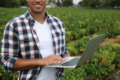 Man with laptop in field, closeup. Agriculture technology