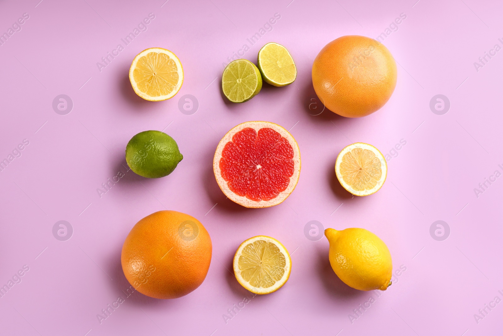 Photo of Flat lay composition with ripe grapefruits on lilac background