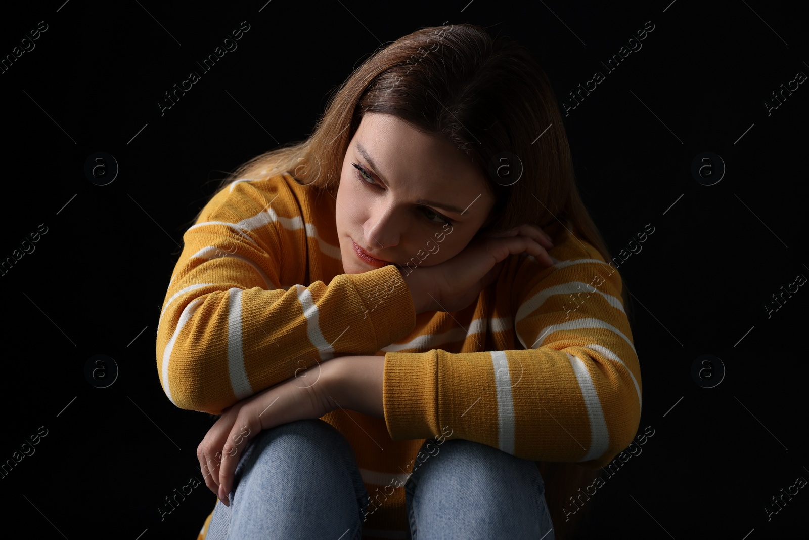 Photo of Portrait of sad woman on black background