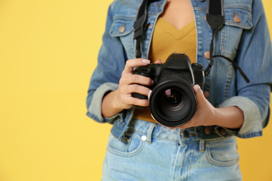 Photo of Professional photographer working on yellow background in studio, closeup