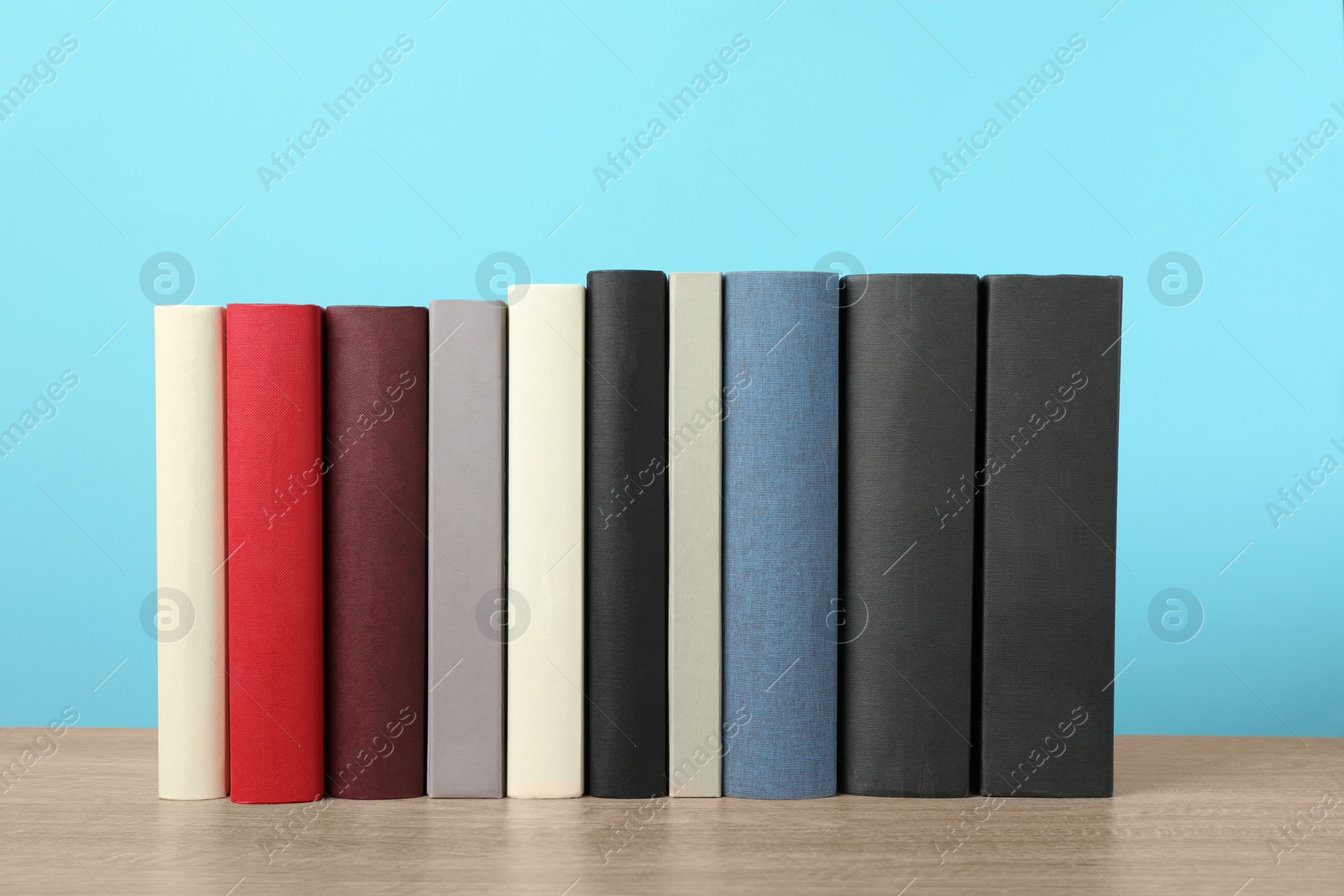 Photo of Many different hardcover books on wooden table