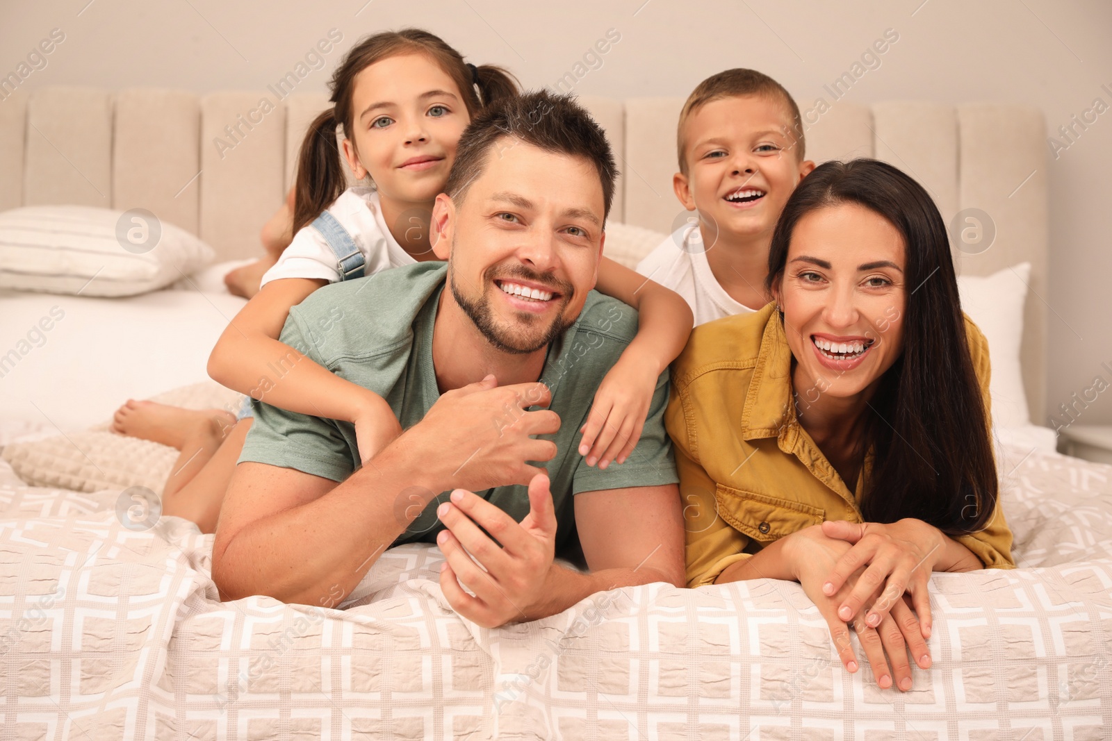 Photo of Portrait of happy family with children on bed at home