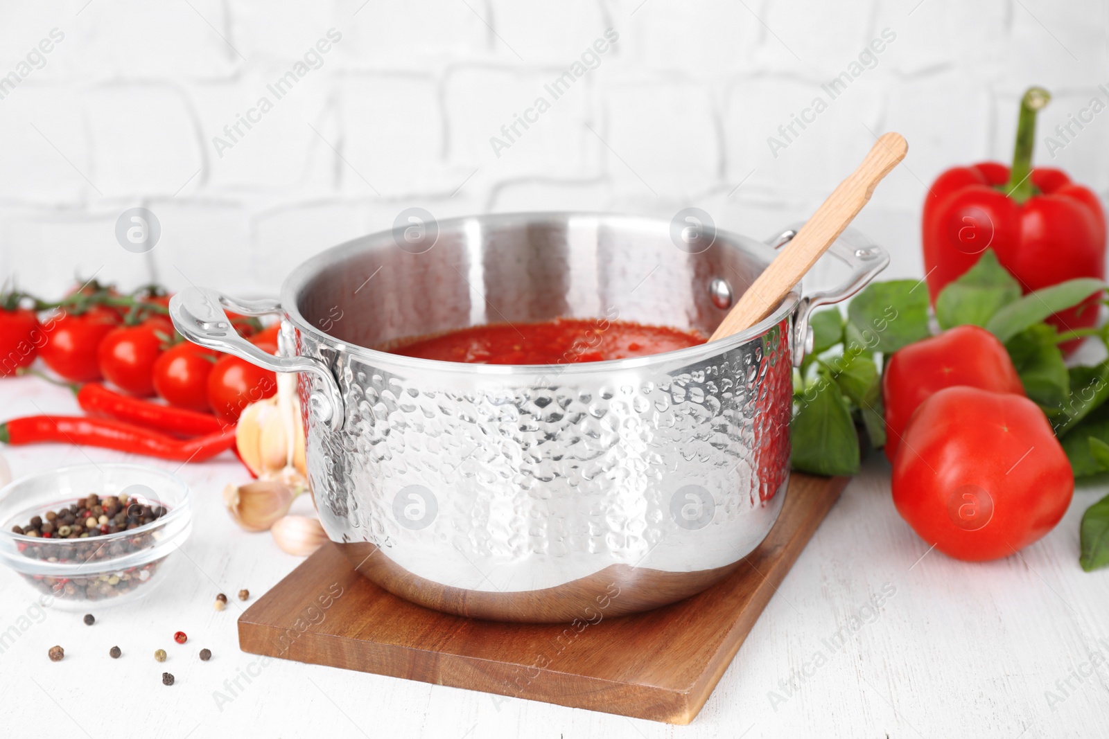 Photo of Delicious tomato sauce and fresh ingredients on white wooden table