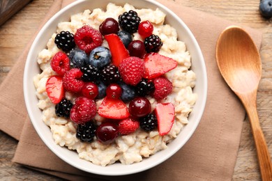 Flat lay composition with tasty oatmeal porridge and ingredients served on wooden table. Healthy meal