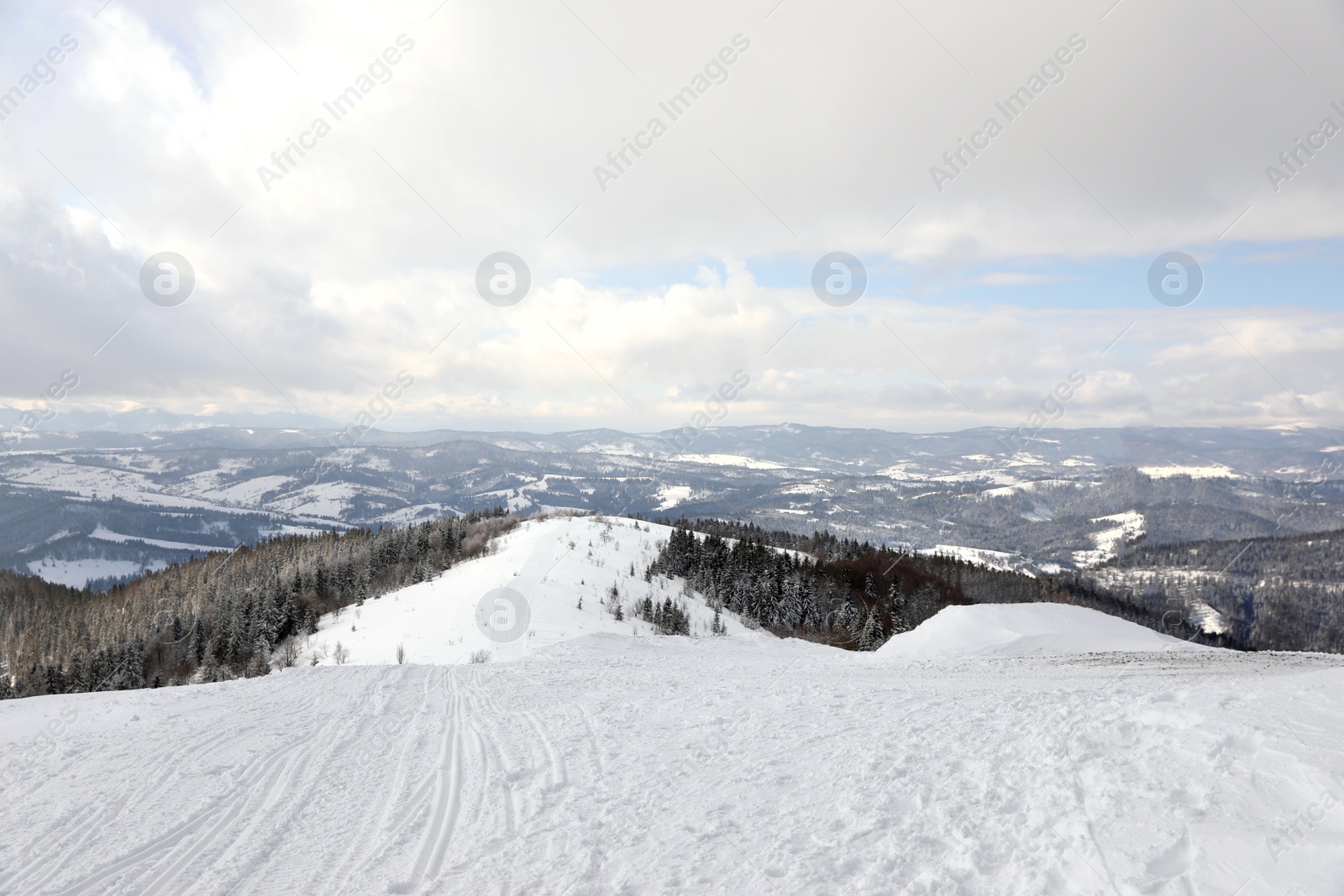 Photo of Picturesque mountain landscape with snowy hills under cloudy sky