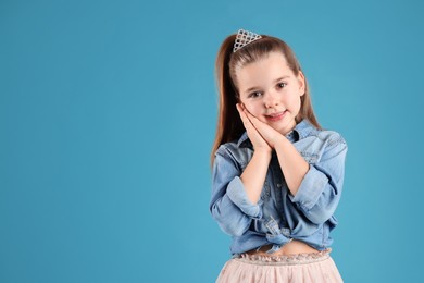 Photo of Cute girl in diadem on light blue background, space for text. Little princess