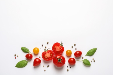 Composition with ripe cherry tomatoes and basil leaves on white background, top view