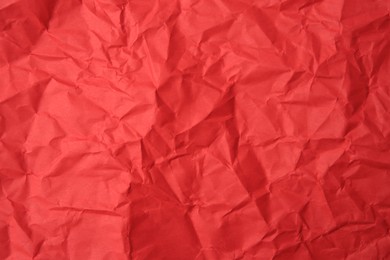 Sheet of crumpled red paper as background, top view