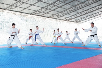 Photo of OCHAKIV, UKRAINE - JULY 09, 2020: Children practicing karate with coach in pavilion. Summer camp "Sportium"