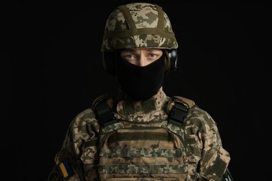 Soldier in Ukrainian military uniform on black background