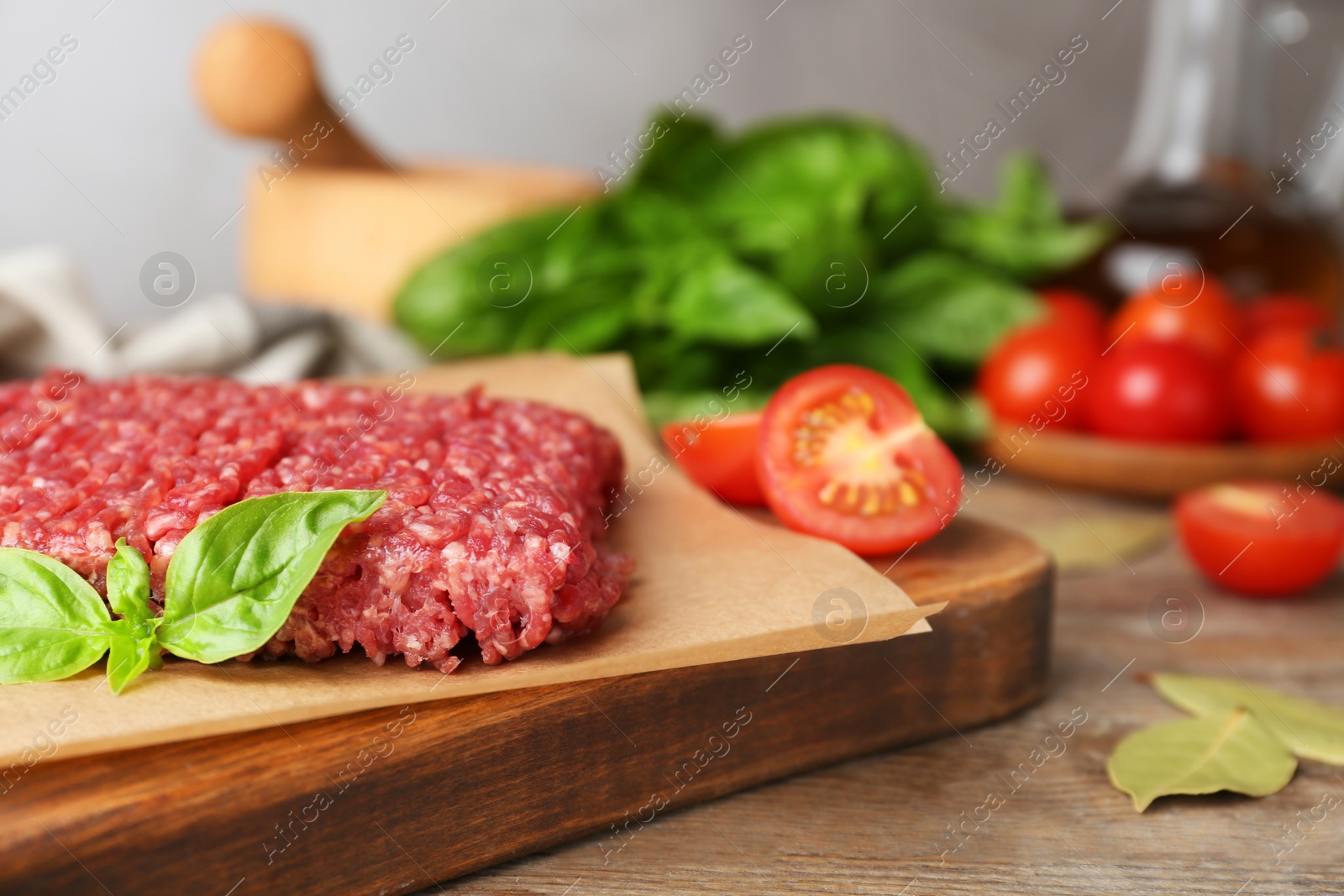 Photo of Fresh raw minced meat and vegetables on wooden table