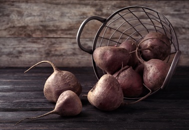 Basket with whole fresh beets on wooden table