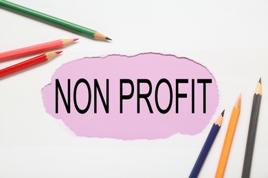 Photo of Non Profit concept. Flat lay composition with colorful pencils on white background