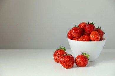 Photo of Fresh juicy strawberries on white table, space for text