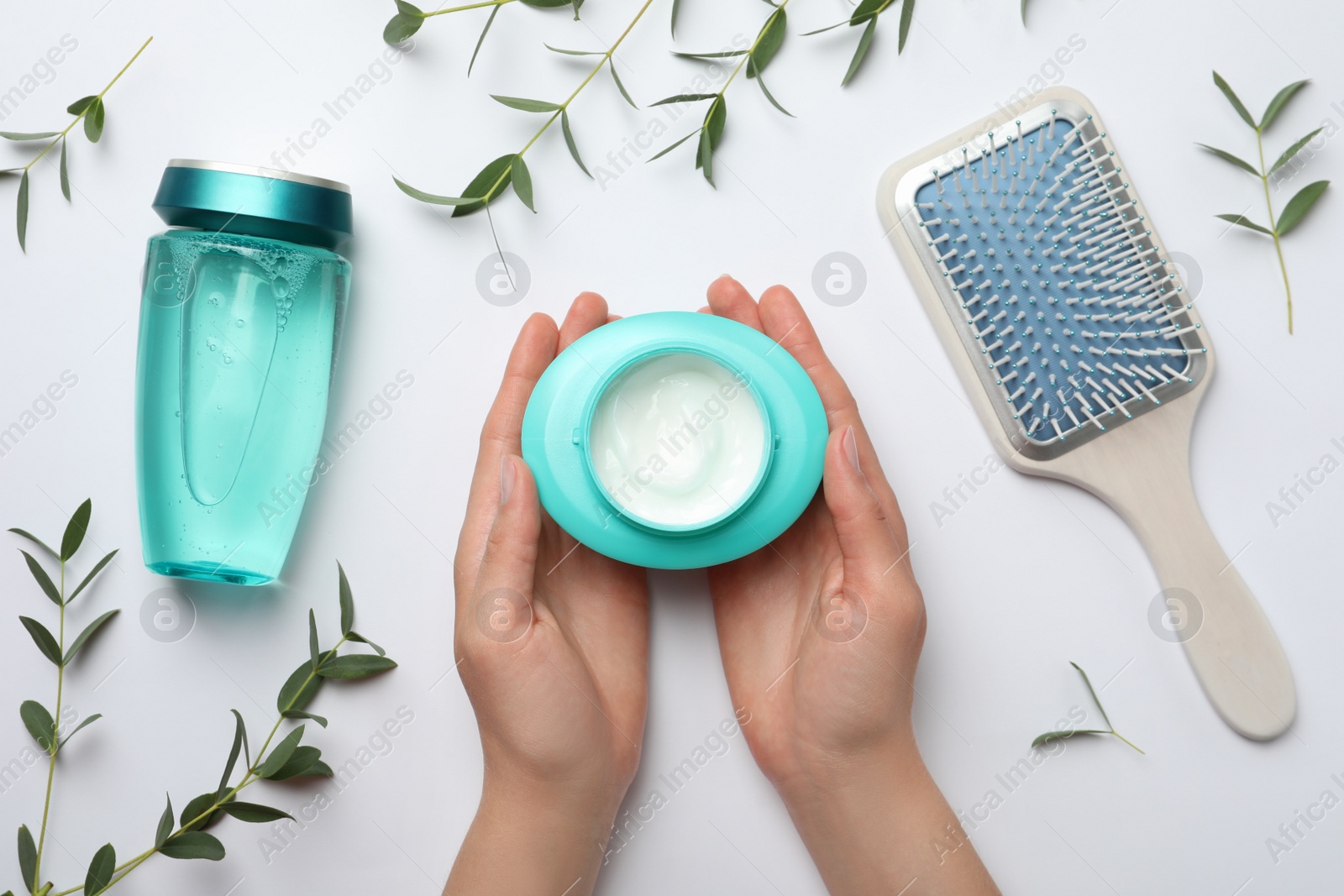 Photo of Woman holding jar with hair care cosmetic product on white background, top view