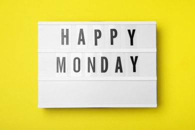 Photo of Light box with message Happy Monday on yellow background, top view