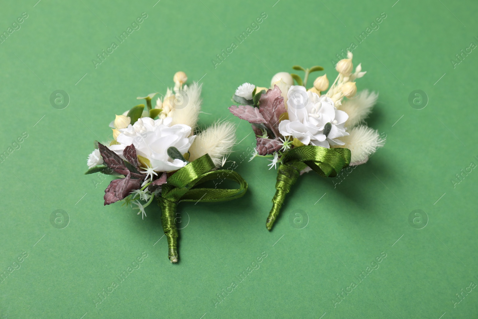 Photo of Stylish boutonniere on green background, flat lay