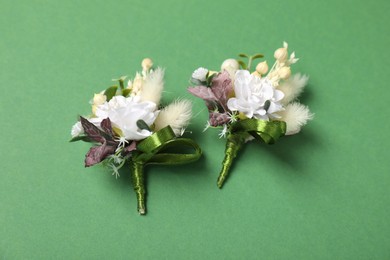 Stylish boutonniere on green background, flat lay