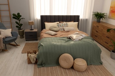 Photo of Large comfortable bed with soft pillows and blanket in room. Home textile