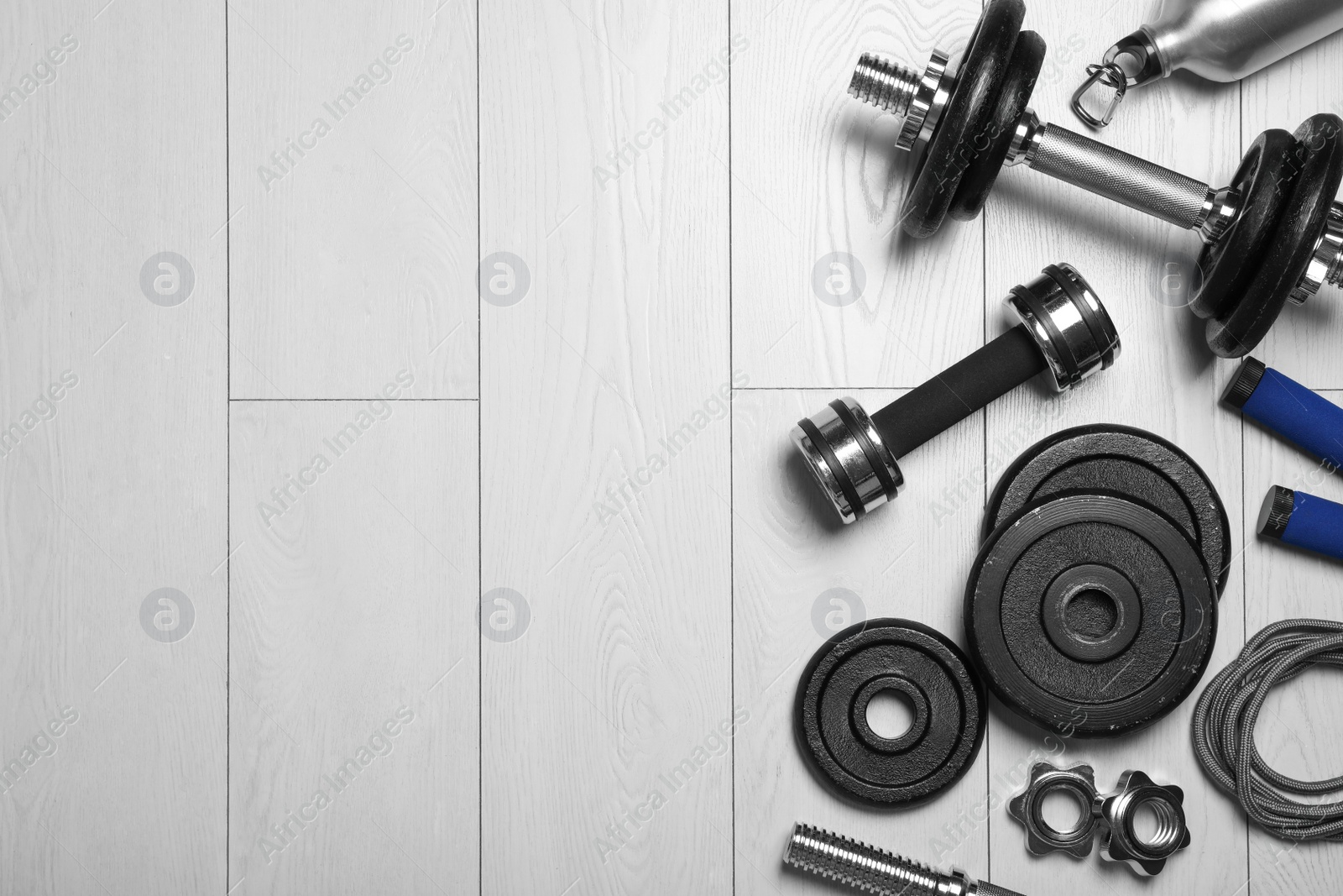 Gym equipment on wooden floor, flat lay. Space for text Photo of Gym equipment on wooden floor, flat lay. Space for text