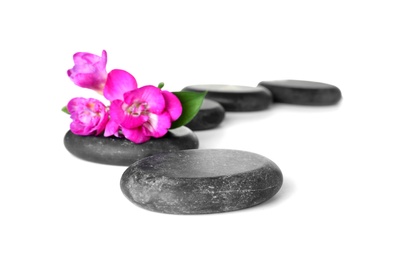 Spa stones and freesia flowers on white background