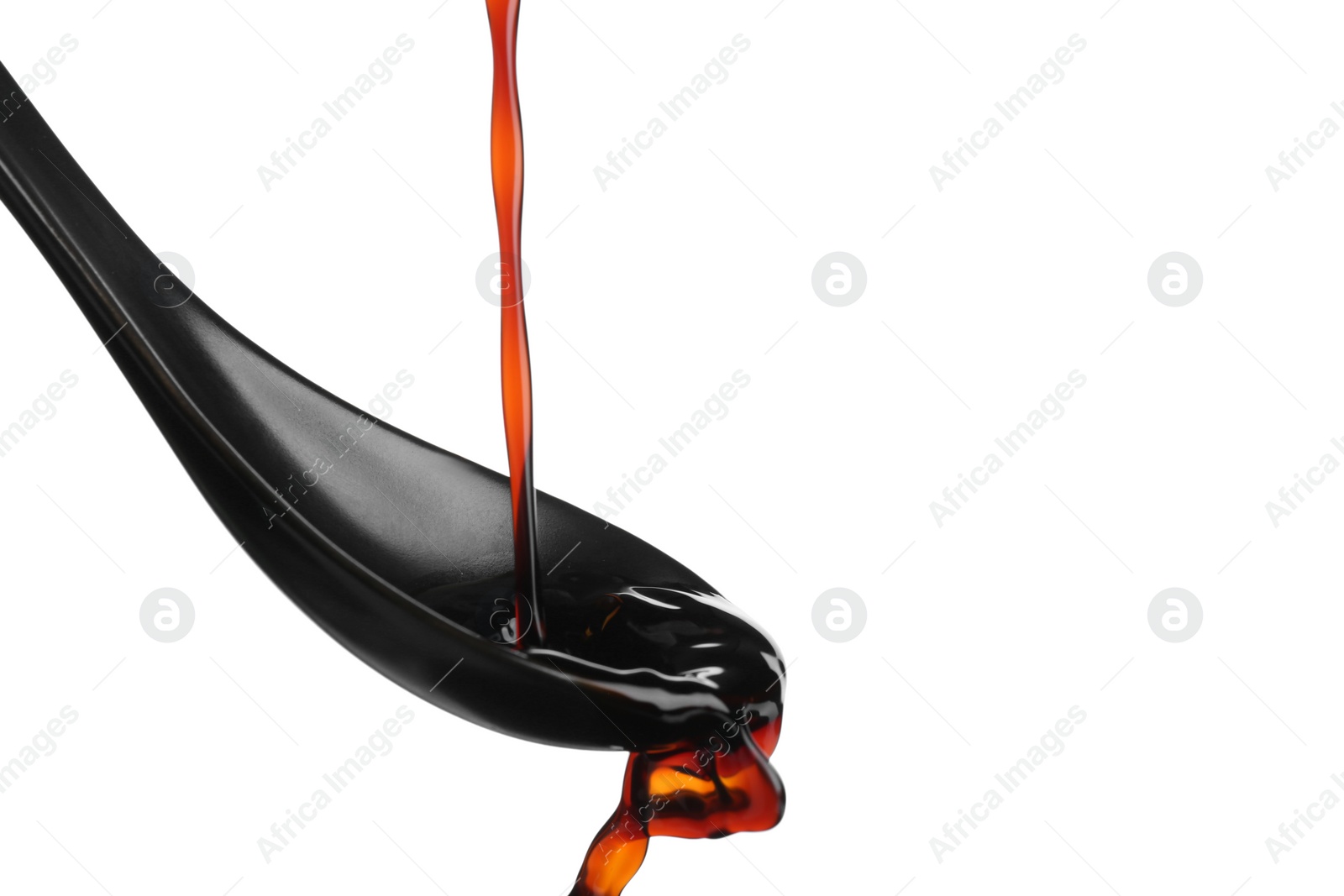 Photo of Pouring soy sauce into spoon against white background