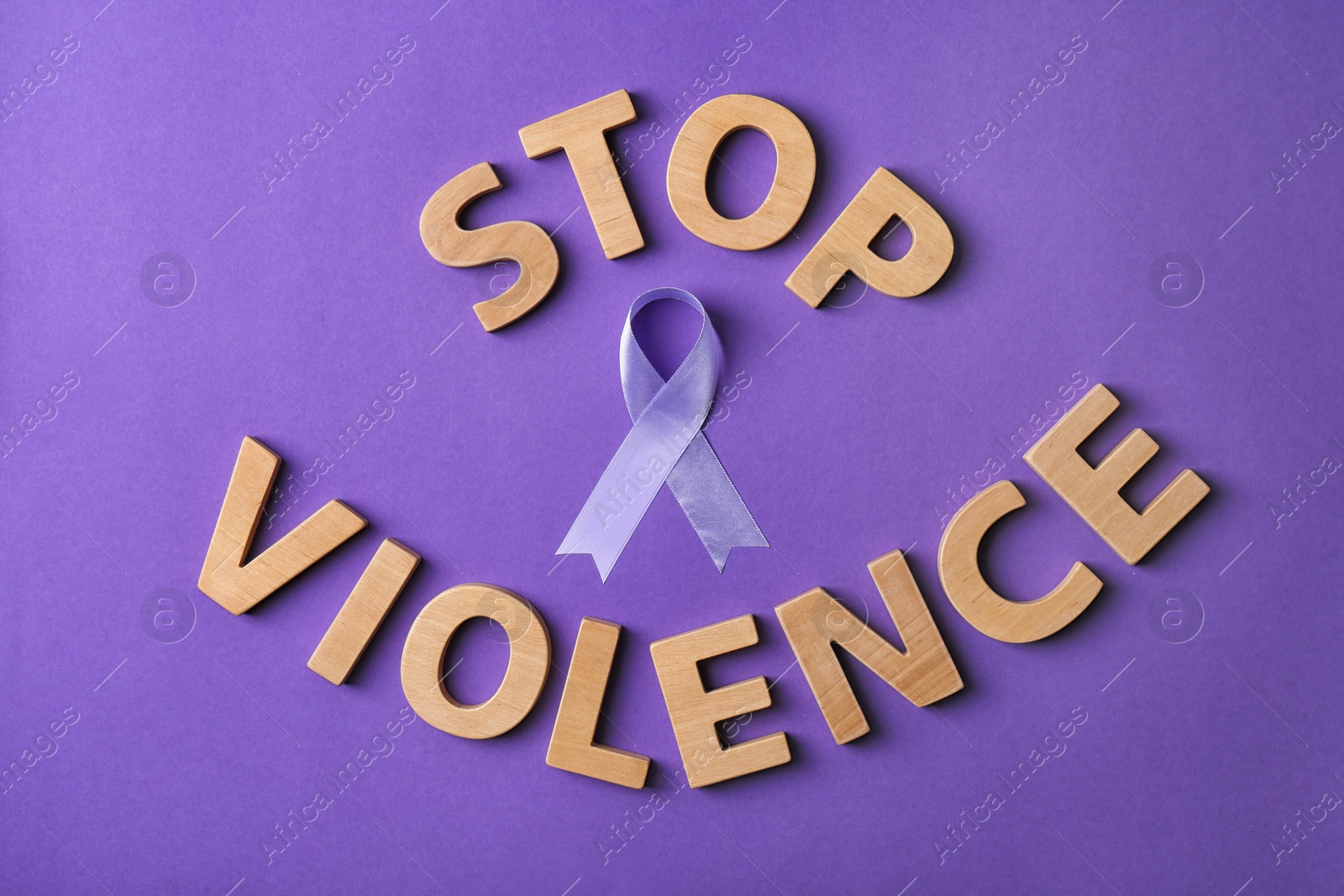 Photo of Flat lay composition with purple ribbon and words STOP VIOLENCE on violet background. Awareness day