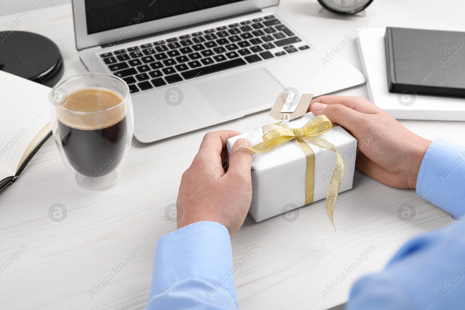 Photo of Man with present from secret Santa at workplace, closeup