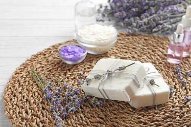 Handmade soap bars with lavender flowers on wicker mat. Space for text