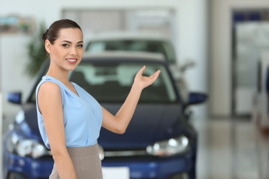 Photo of Attractive young saleswoman in car dealership