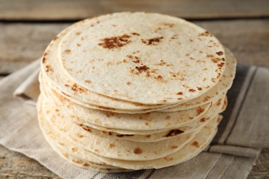 Stack of tasty homemade tortillas on wooden table, closeup