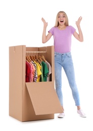 Photo of Young emotional woman near wardrobe box on white background