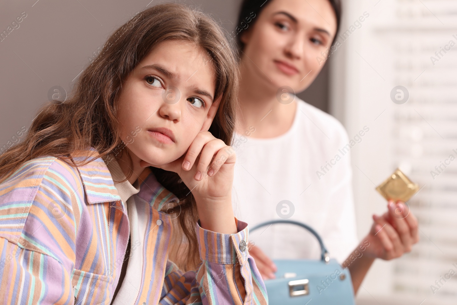 Photo of Mother putting condom into daughter's bag at home. Sex education concept