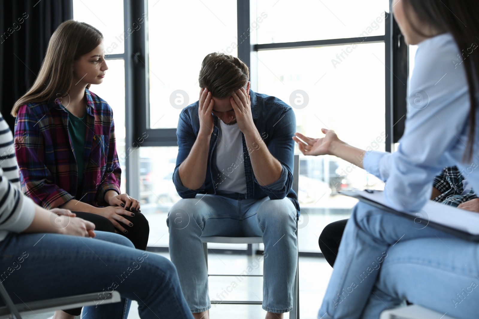 Photo of Psychotherapist working with patients in group therapy session indoors