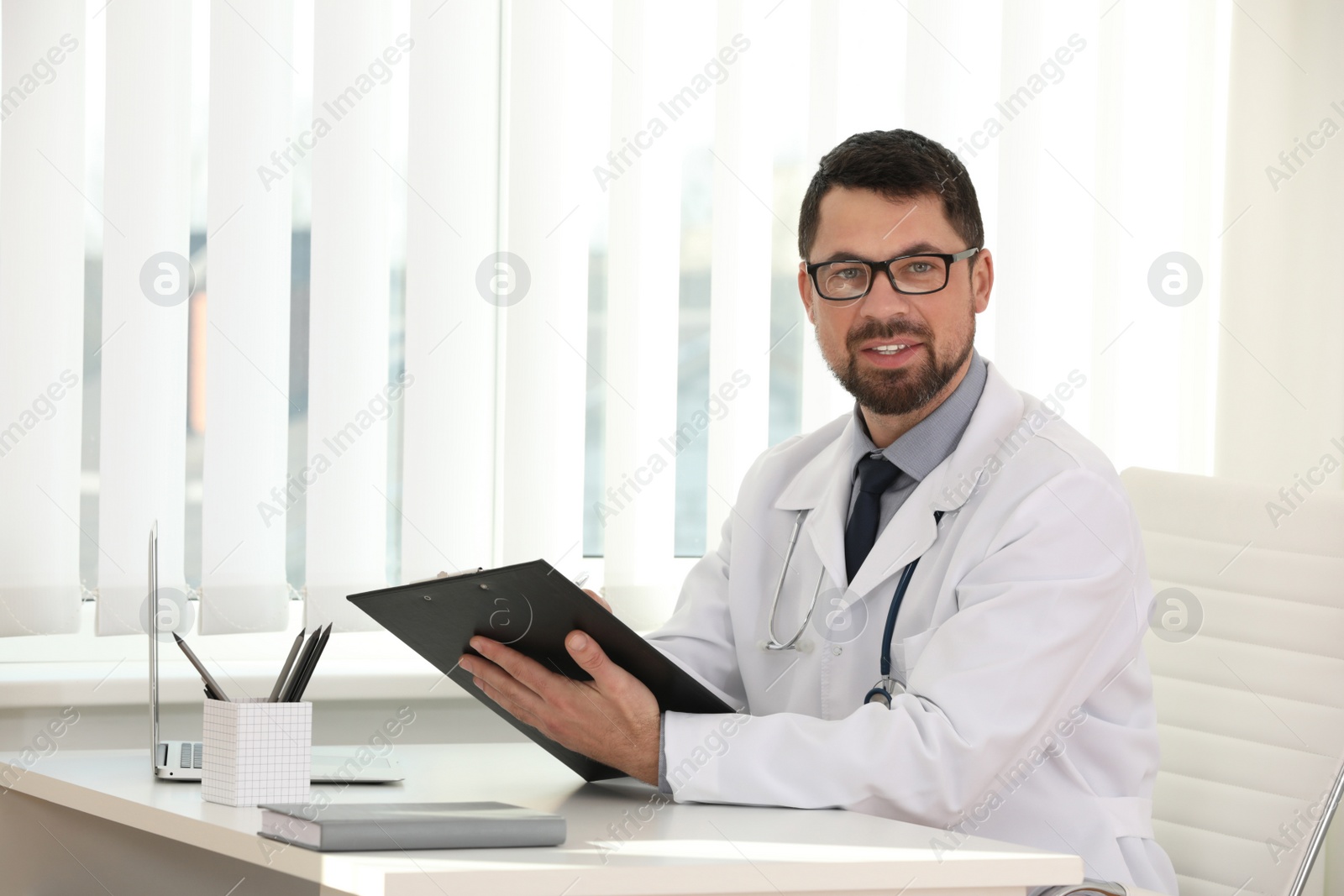 Photo of Portrait of male doctor in white coat at workplace