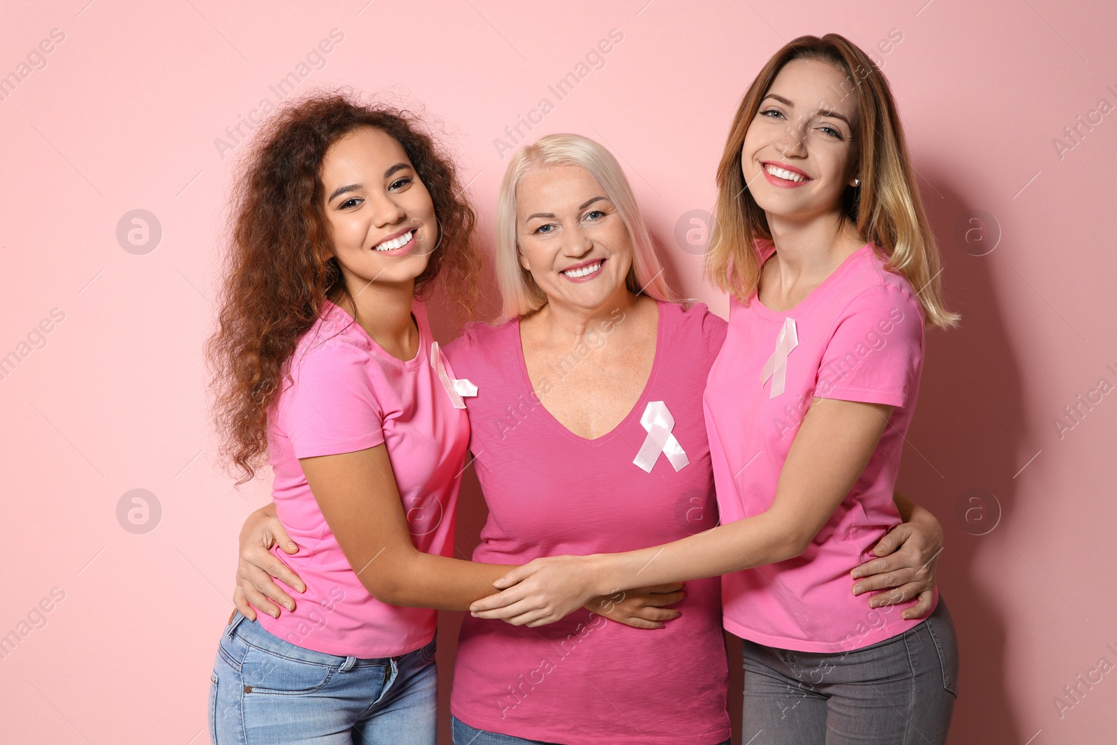 Photo of Group of women with silk ribbons on color background. Breast cancer awareness concept