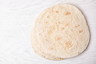 Photo of Corn tortillas and space for text on white wooden background, top view. Unleavened bread