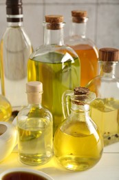Vegetable fats. Different oils in glass bottles on white table, closeup