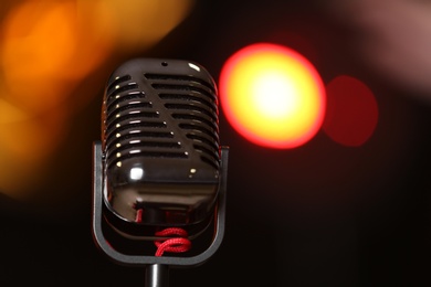 Photo of Retro microphone against festive lights, space for text. Musical equipment