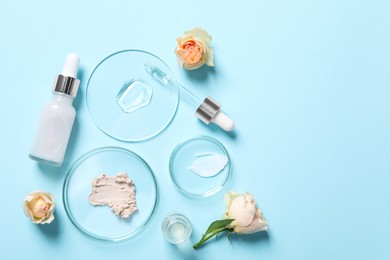 Photo of Bottle of cosmetic serum, flowers and petri dishes with samples on light blue background, flat lay. Space for text