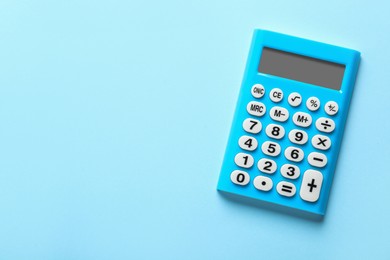 Light blue calculator on turquoise background, top view. Space for text