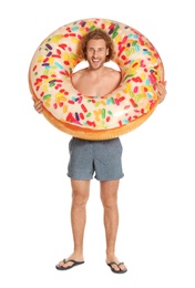 Photo of Attractive young man in swimwear with doughnut inflatable ring on white background