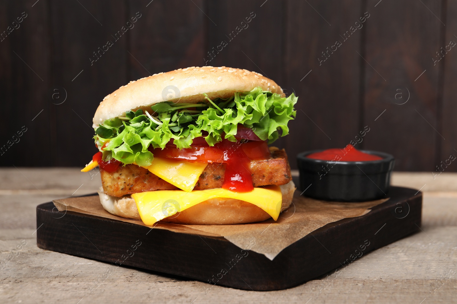 Photo of Delicious tofu burger served with sauce on wooden table