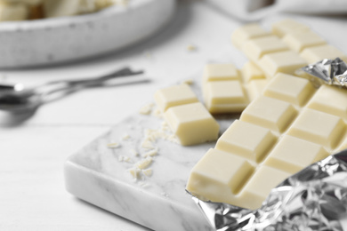 Photo of Tasty white chocolate on wooden table, closeup