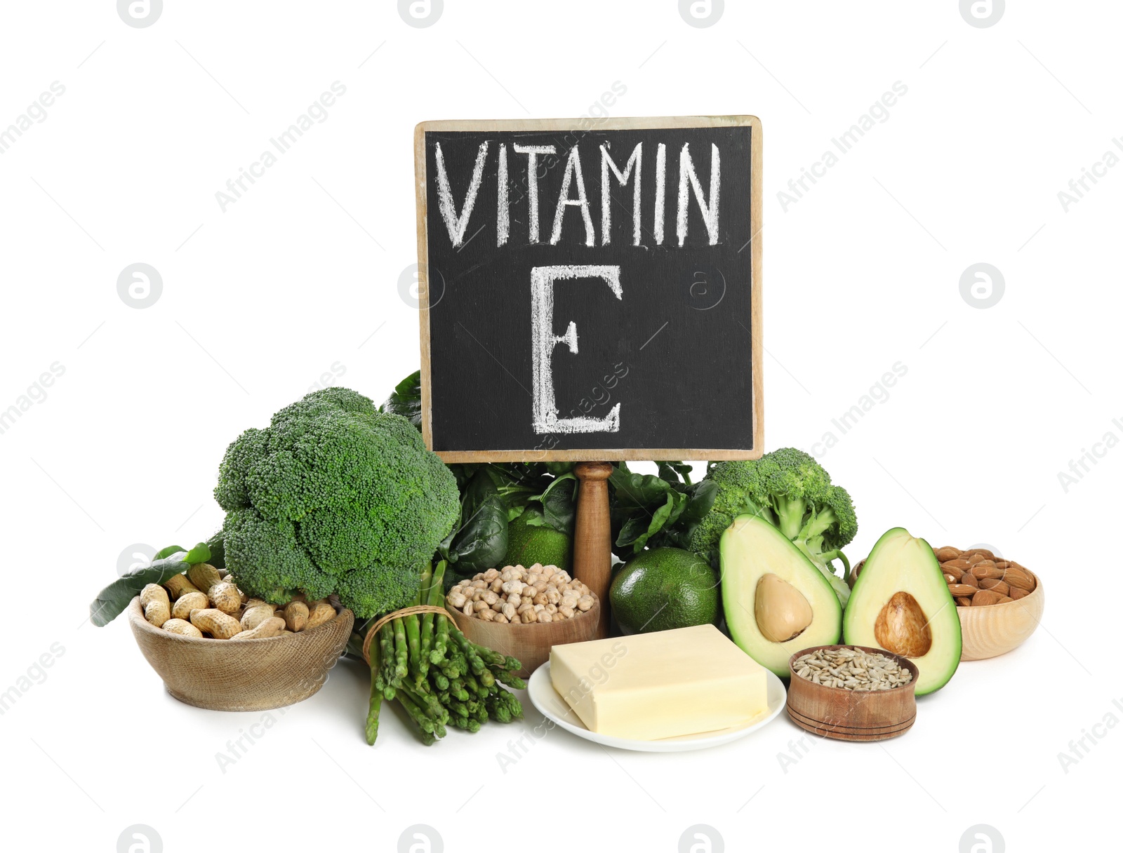 Photo of Small chalkboard with phrase Vitamin E and different products on white background