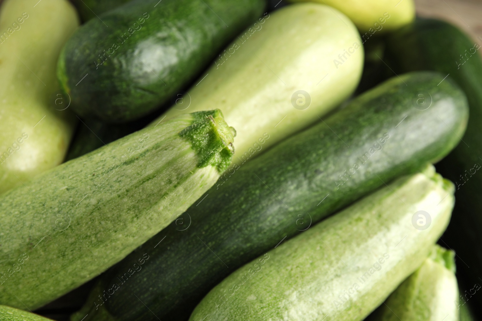 Photo of Top view of fresh ripe zucchini as background, closeup