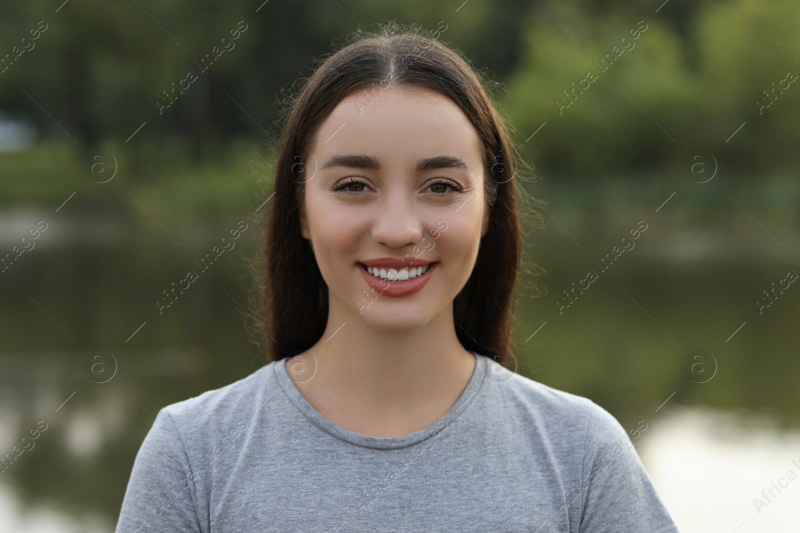 Photo of Portrait of beautiful woman outdoors. Attractive lady smiling and looking into camera