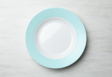 Photo of Stylish ceramic plate on white wooden background, top view