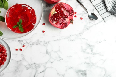 Photo of Flat lay composition with pomegranate jelly in bowl on marble table. Space for text